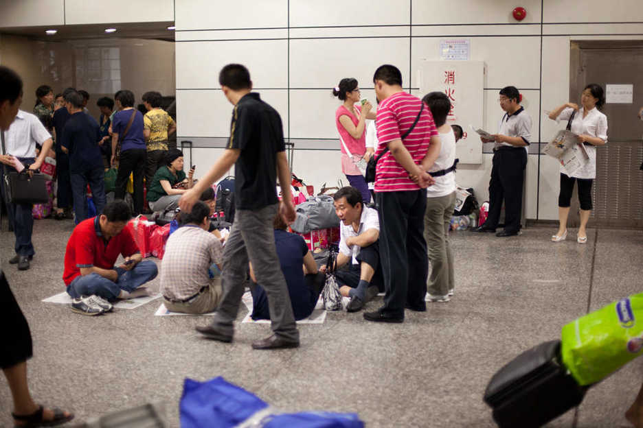 Group of travelers playing cards in the Guangzhou, China train station.