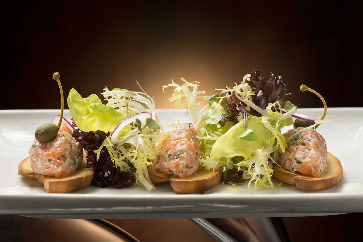 Food photograph of smoked salmon tartar with chives, caper-lemon yogurt and mini toasted baguette at the Aux Beaux Arts restaurant in Macau's MGM resort.