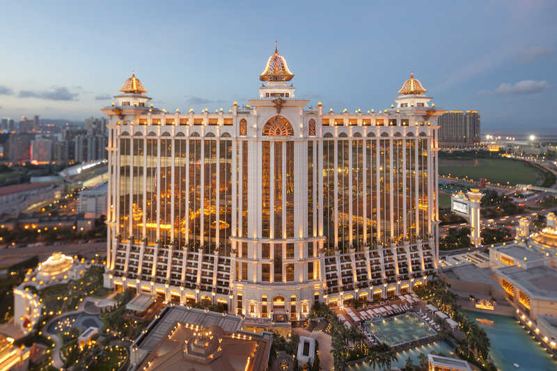 One of the two Galaxy Macau towers are illuminated at dusk