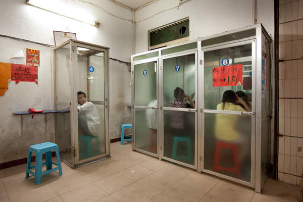 People use wired telephones at a shop in Yuancun village