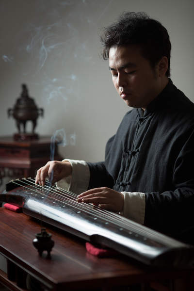 A musician plays the guqin at his studio across the street from Kaifu Temple