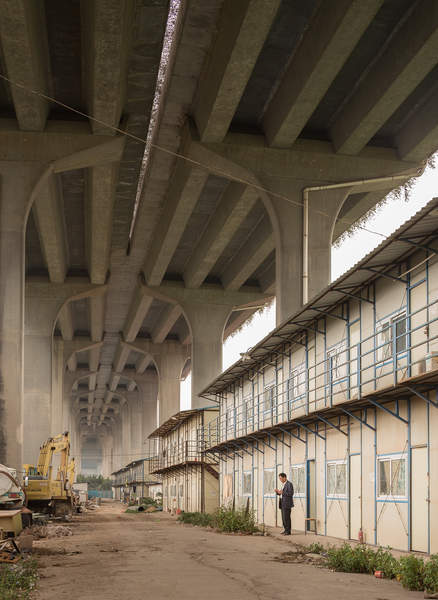 A worker stands under the Xinguang Expressway in Haizhou District