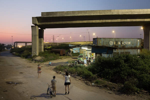 People walk near a convenience store operating out of a shipping container in Foshan