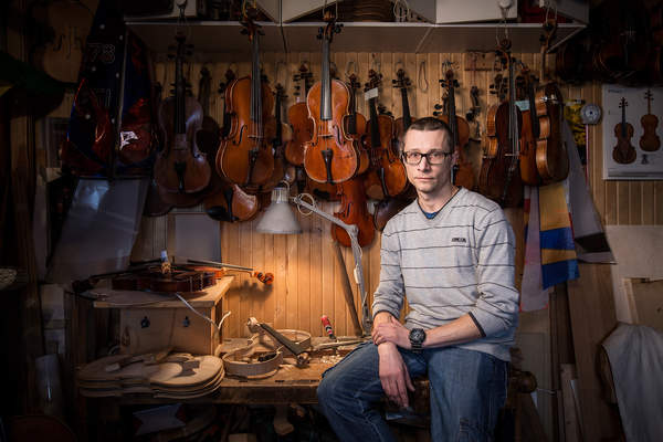 Violin maker Bartosz Wozniak poses at the workshop he shares with his father in Warsaw