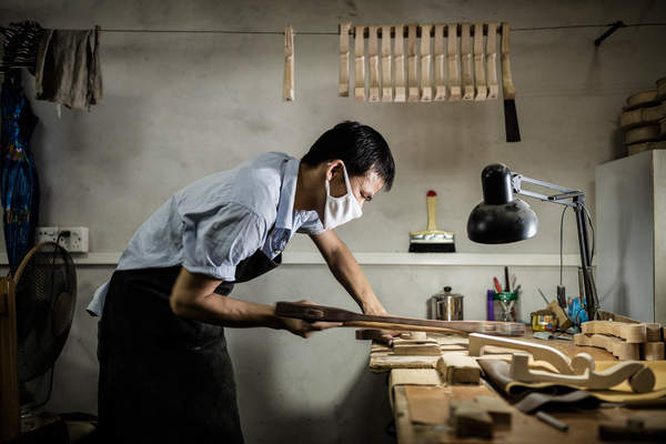 A craftsman works at the Noble Heart Violin Workshop in Guangzhou, China.