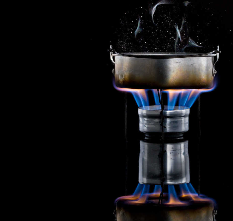 Penny backpacking stove with pot of boiling water