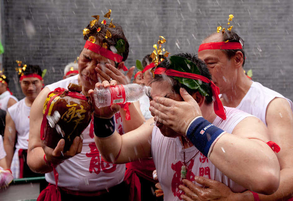 Drunken Dragon festival reveler washes the alcohol from his eyes with water
