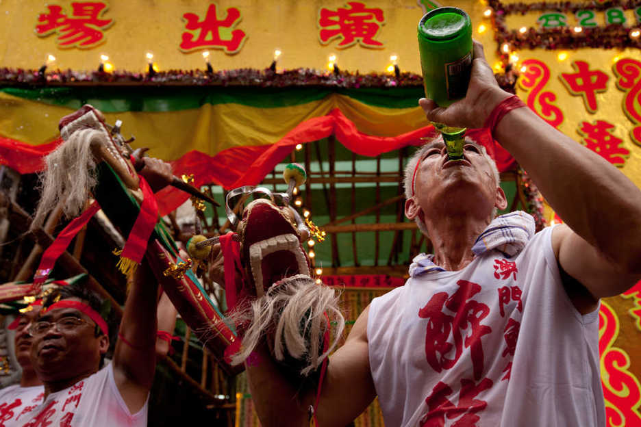 A Drunken Dragon performer guzzles beer in front of Kuan Tai Temple