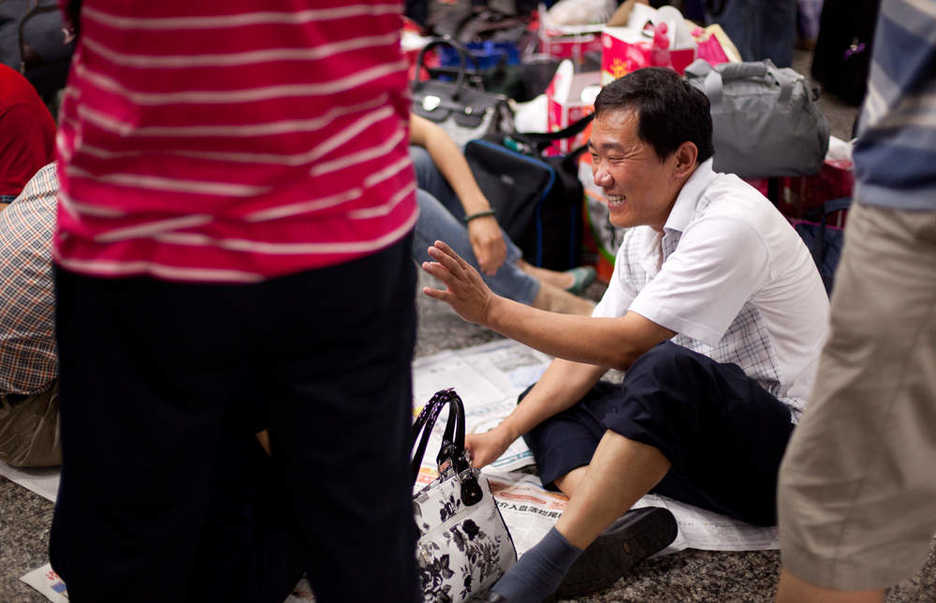 Man playing cards in the Guangzhou, China train station.