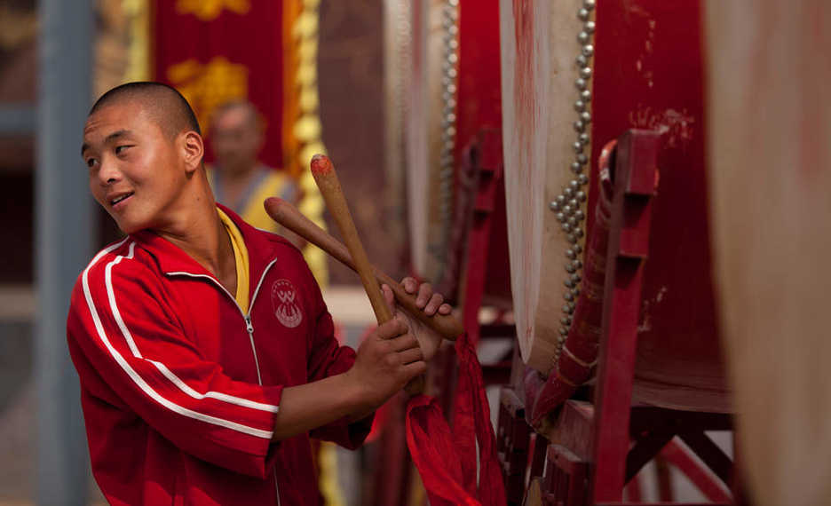 A kung fu student tries a drum at Shaolin Si in Dengfeng, Henan province, China