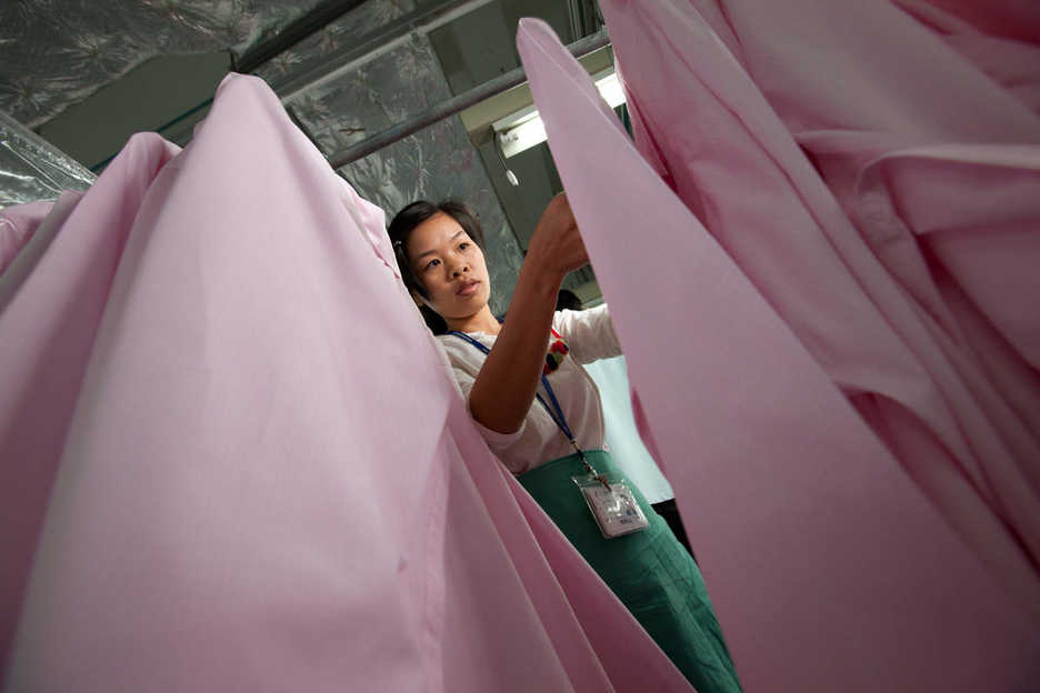 A worker inspects shirts at the Lever Style factory in Guan Lan, Shenzhen, China