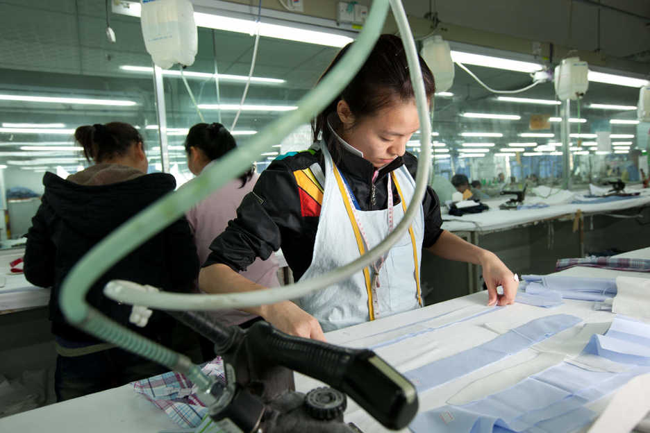 A worker irons fabric at the Lever Style factory in Guan Lan, Shenzhen, China