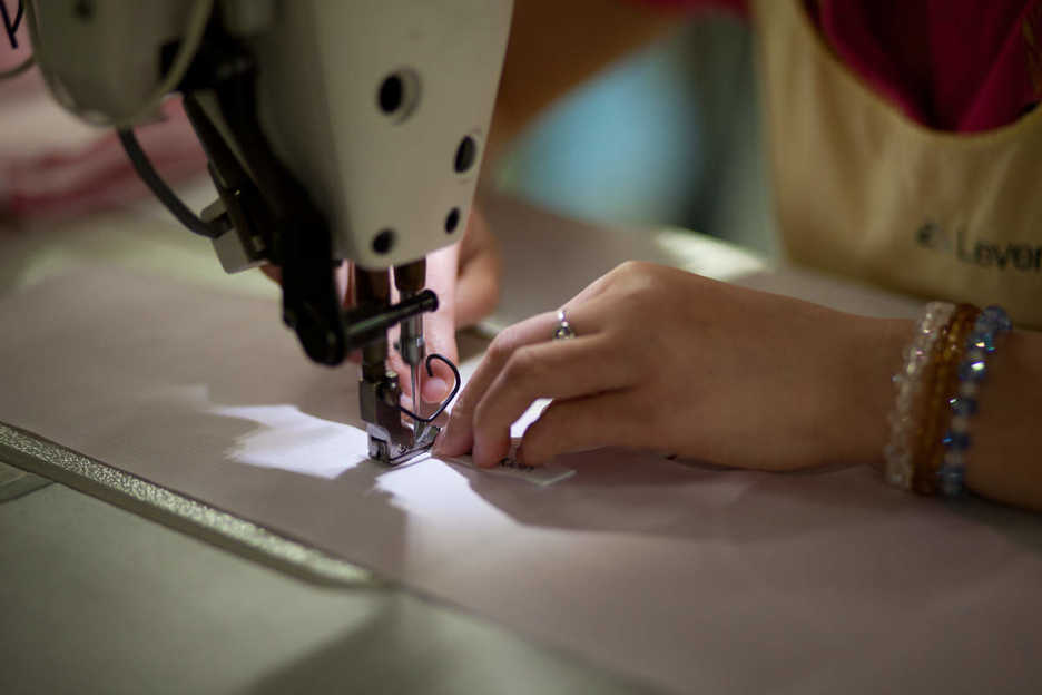 A worker sews fabric at the Lever Style factory in Guan Lan, Shenzhen, China