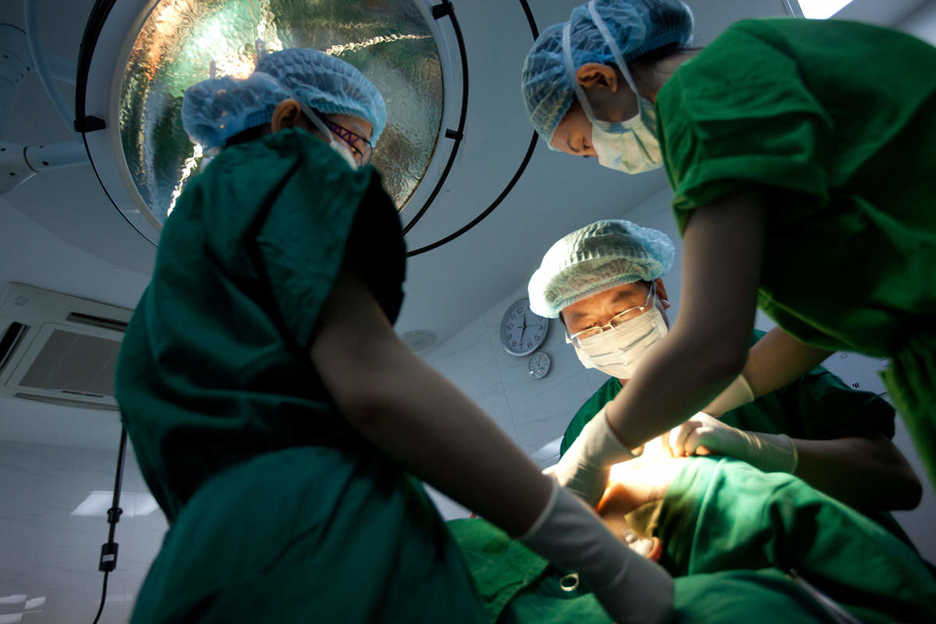 Li Yujie applies sutures to patient after performing operation to enlarge nose