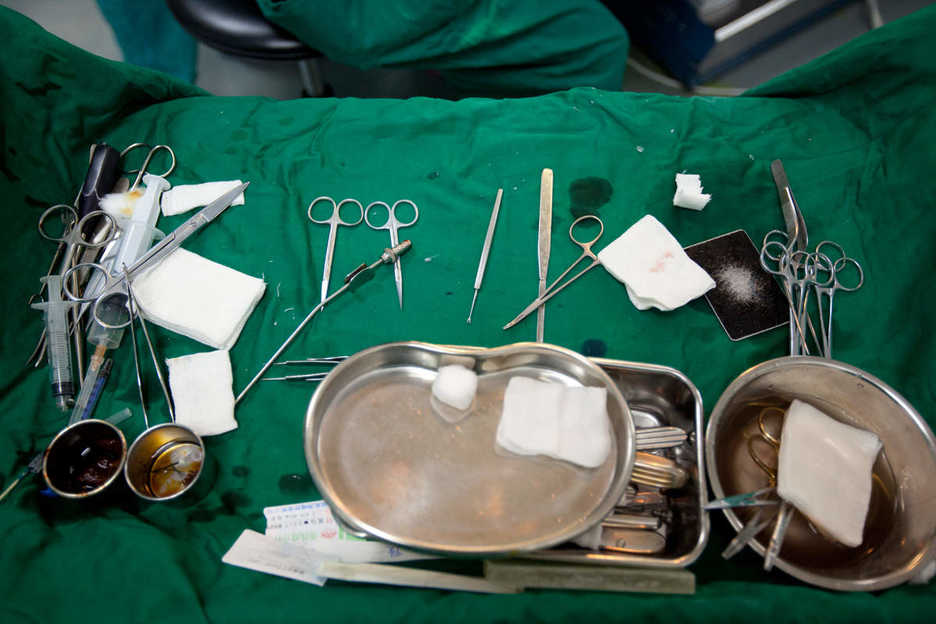 Medical implements rest on a table near a patient at Shenzhen Humanity Hospital