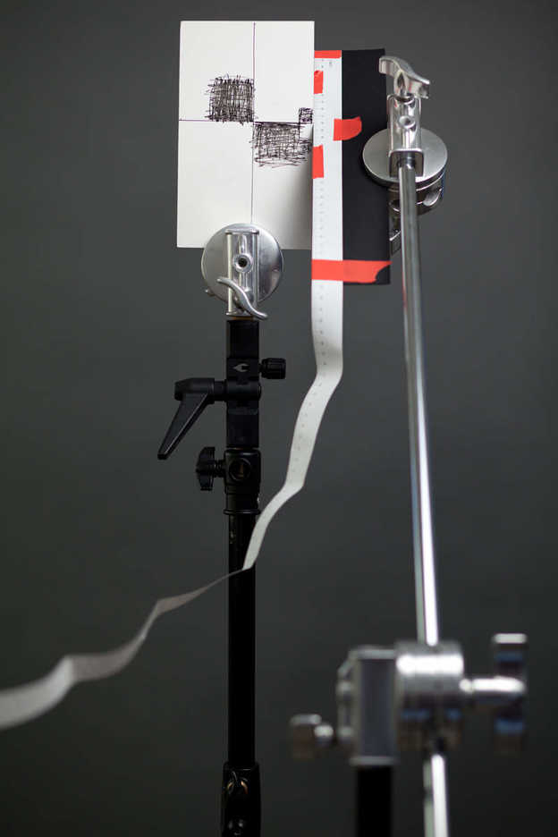 DIY lens calibration test target and gauge held by photography grip equipment