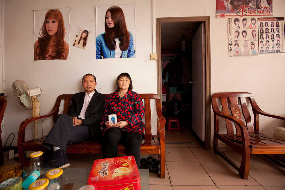 Peng Haiying and her husband Zhu DaoLin hold a photograph of their missing son at their hair salon in Dongguan, Guangdong Province, China