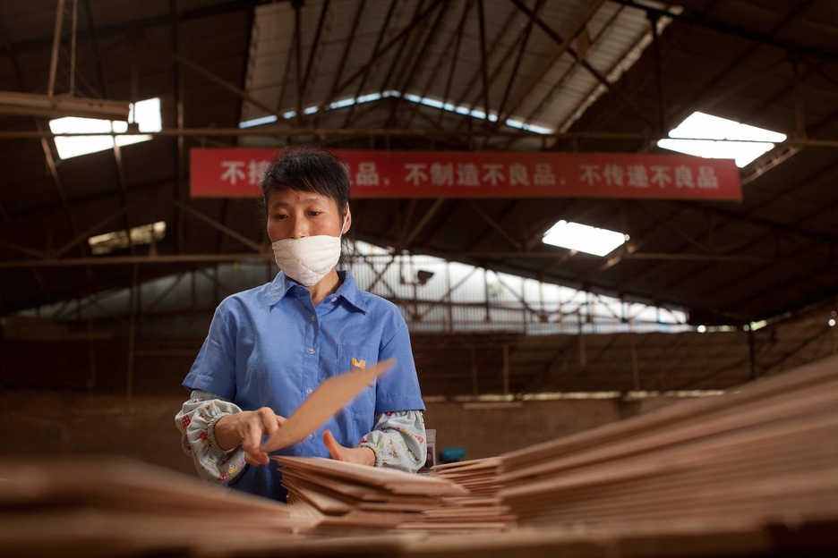 A worker sorts wood at the Hongyuan furniture factory in Panyu, Guangzhou