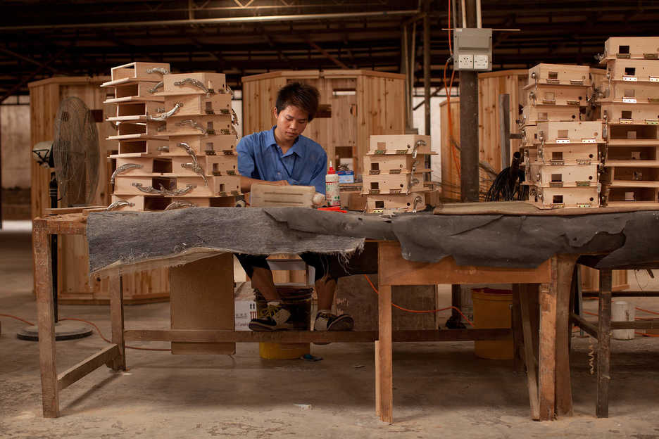 A worker assembles stereo boxes at the Hongyuan furniture factory in Panyu, Guangzhou"