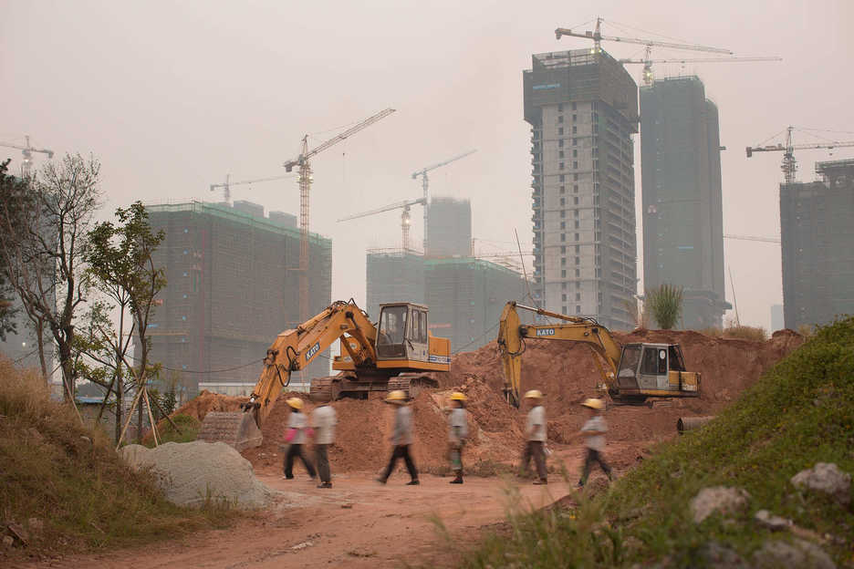 Construction workers walk through a residential development in Haizhu District, Guangzhou