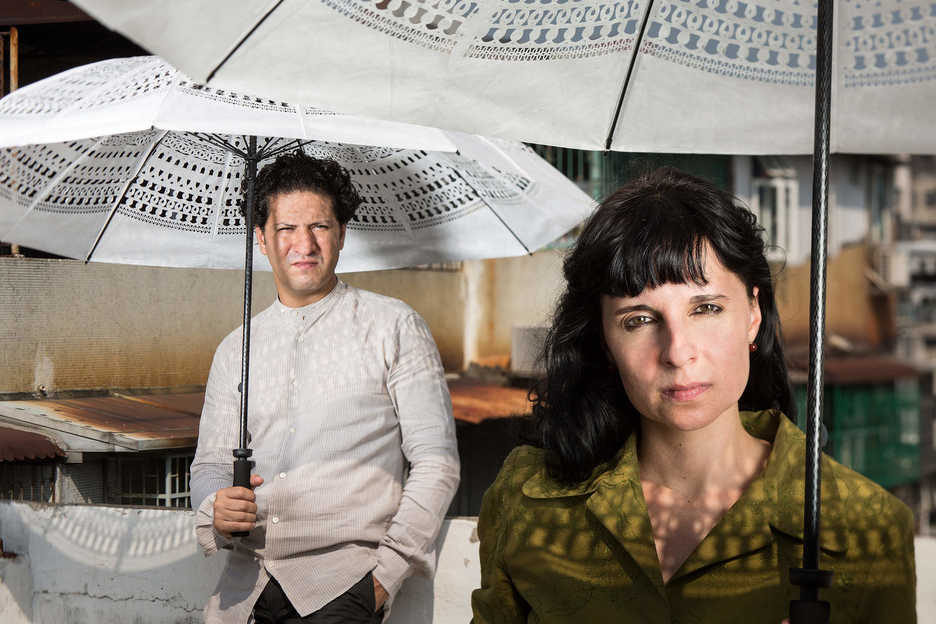 Manuel CS and Clara Brito pose with Lines Lab umbrellas on the roof of their studio building