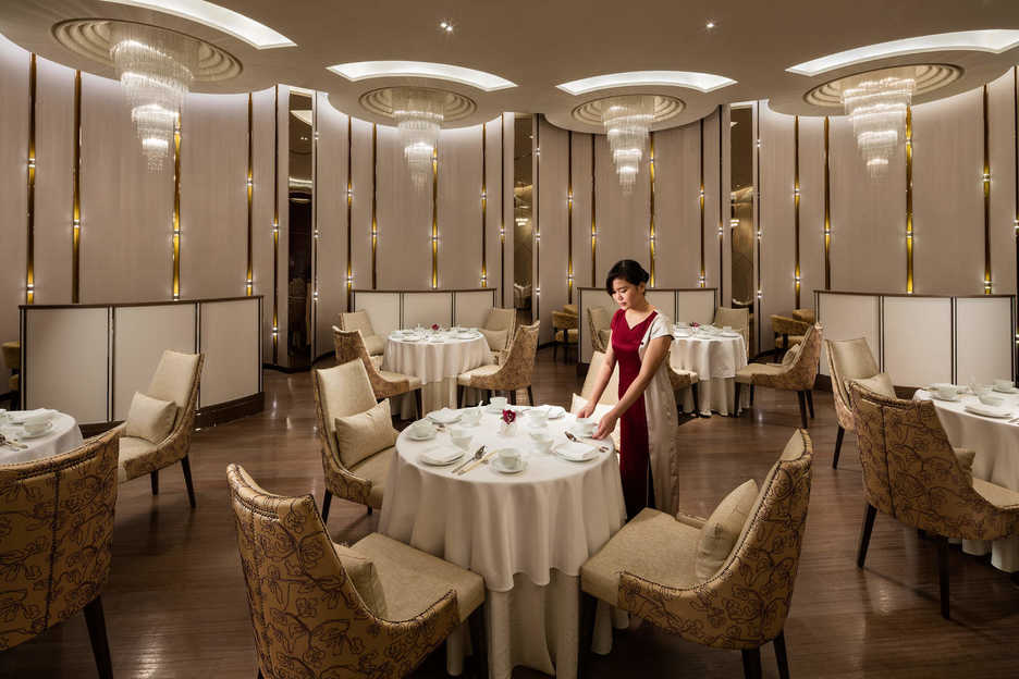 A waitress poses at a table in the Man Ho restaurant in Macau