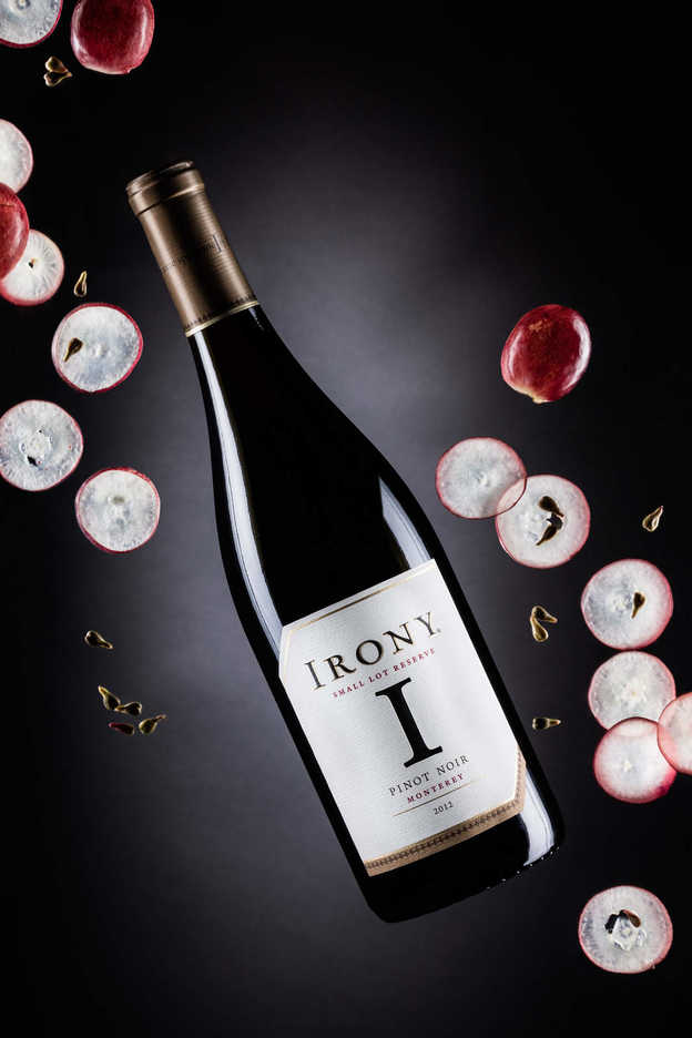 Bottle of Irony pinot noir from Monterey, California photographed with grapes