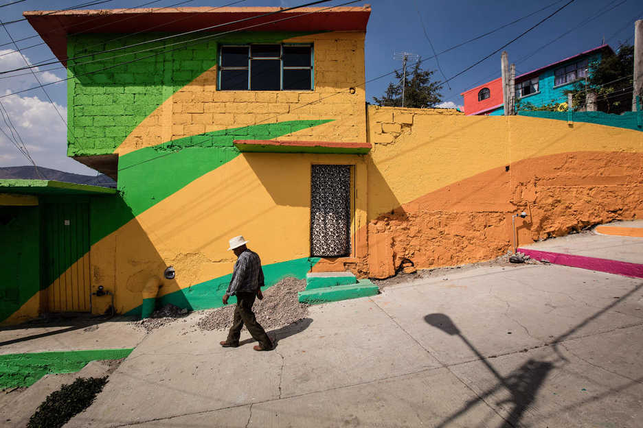 A man walks by a painted building in Colonia Las Palmitas