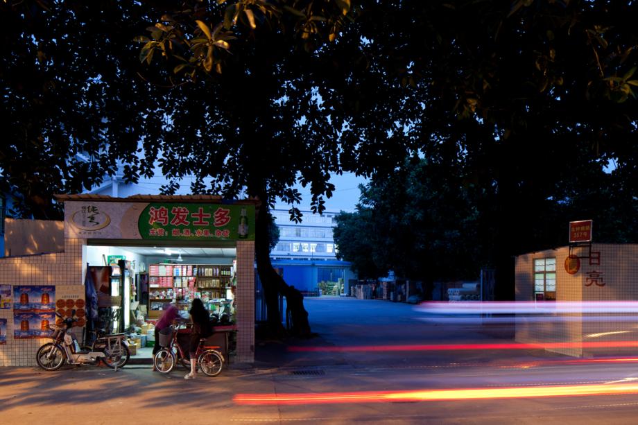 woman with electric bicycle at street-side convenience store in Baiyun district