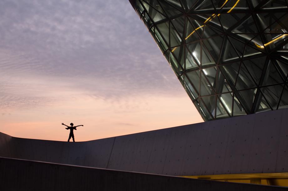 A statue is seen at dusk on a balcony at the Guangzhou Opera House designed by Zaha Hadid