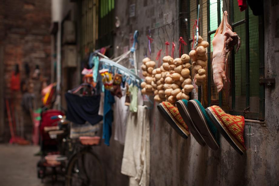 Shoes, pork, and other things hang off a window in Sanyuanli Village