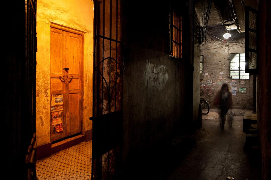 A woman walks in an alleyway in Sanyuanli Village