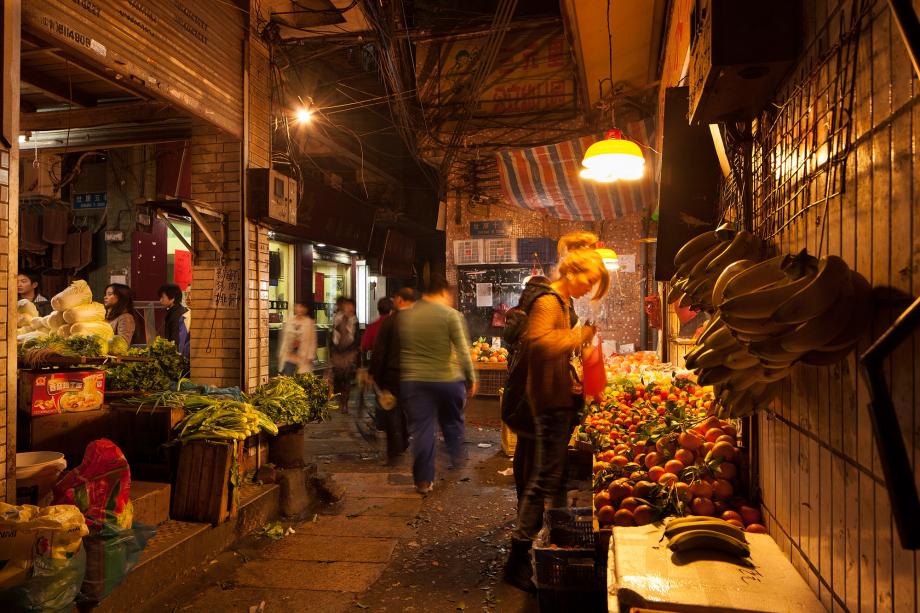 People shop for fruit and vegetables in Sanyuanli Village