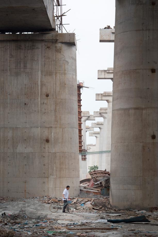 A man walks under high speed rail tracks under construction in Liwan, Guangzhou