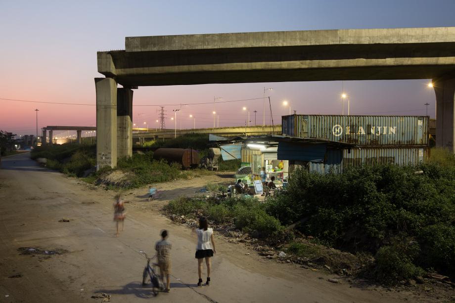 People stand near an unfinished elevated roadway in Foshan, China.