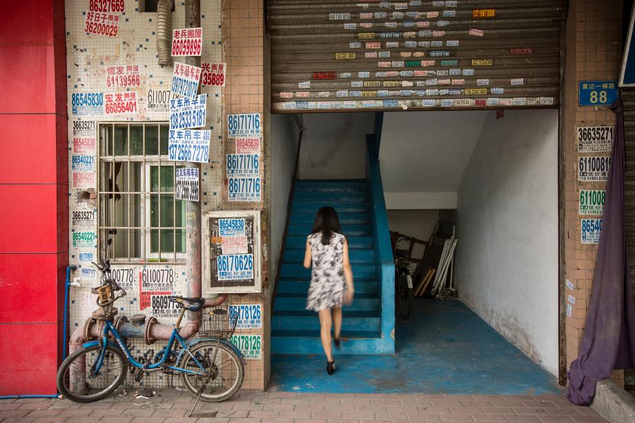 A woman walks up a stairway in a small factory building in Baiyun District, Guangzhou